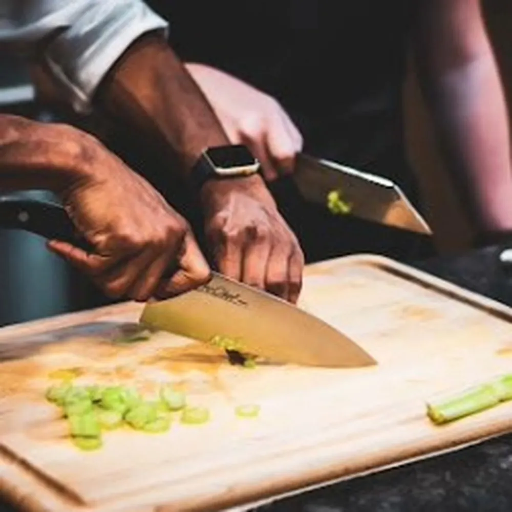 Chef Corey demonstrating knife technique on a cutting board