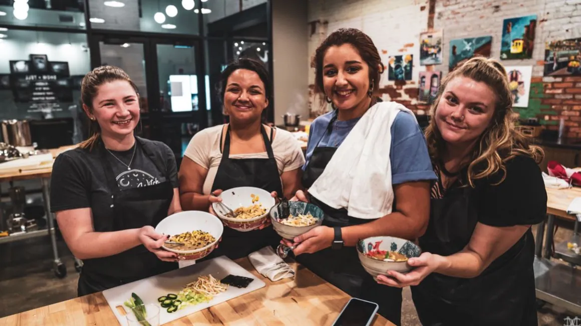 A class group holding up the bowls they cooked