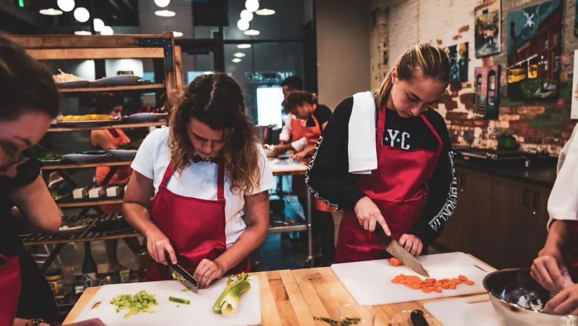 Participants chopping vegetables during a hands-on Iron Chef Core cooking class