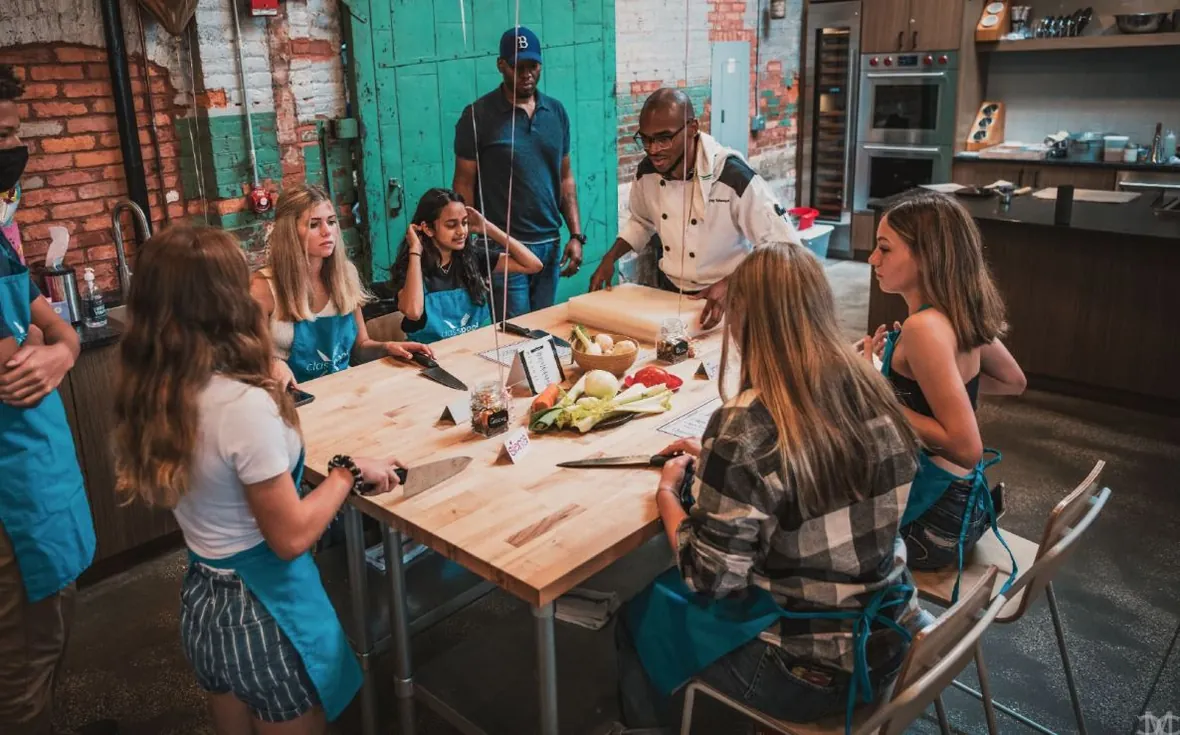 A group seated together at the long table after an Iron Chef Core class