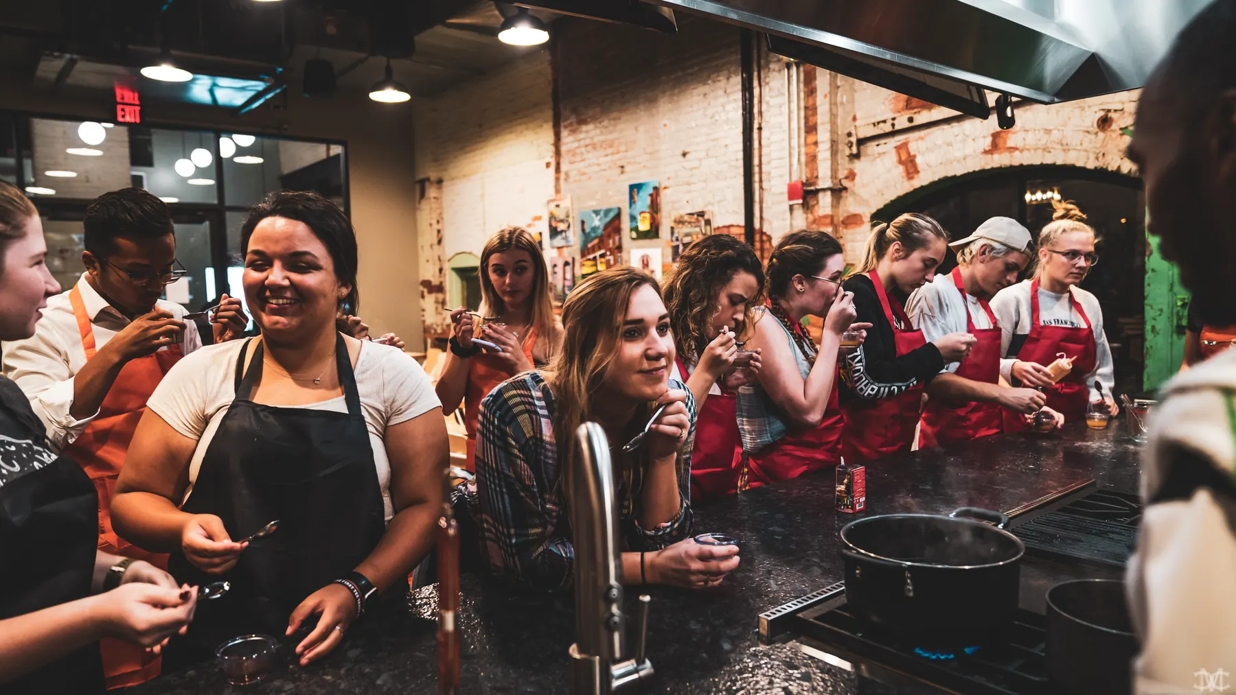 Guests gathered around the cooktop during an Iron Chef Core class at Armature Works